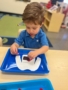 male child engaging in hands on learning activity at little big minds uptown