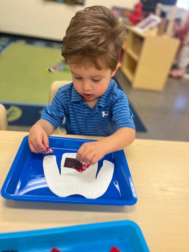 male child engaging in hands on learning activity at little big minds uptown
