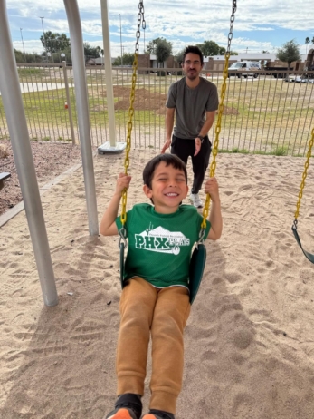 male child on swing on playground at little big minds uptown