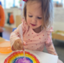 Child painting rainbow at preschool and daycare at cadence academy preschool 452 south street