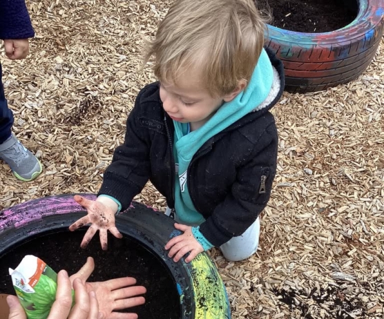 child playing outside in dirt in bucket preschool and daycare newton school for children 455