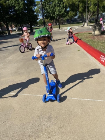 child on scooter at preschool and daycare at 335 peter's Colony