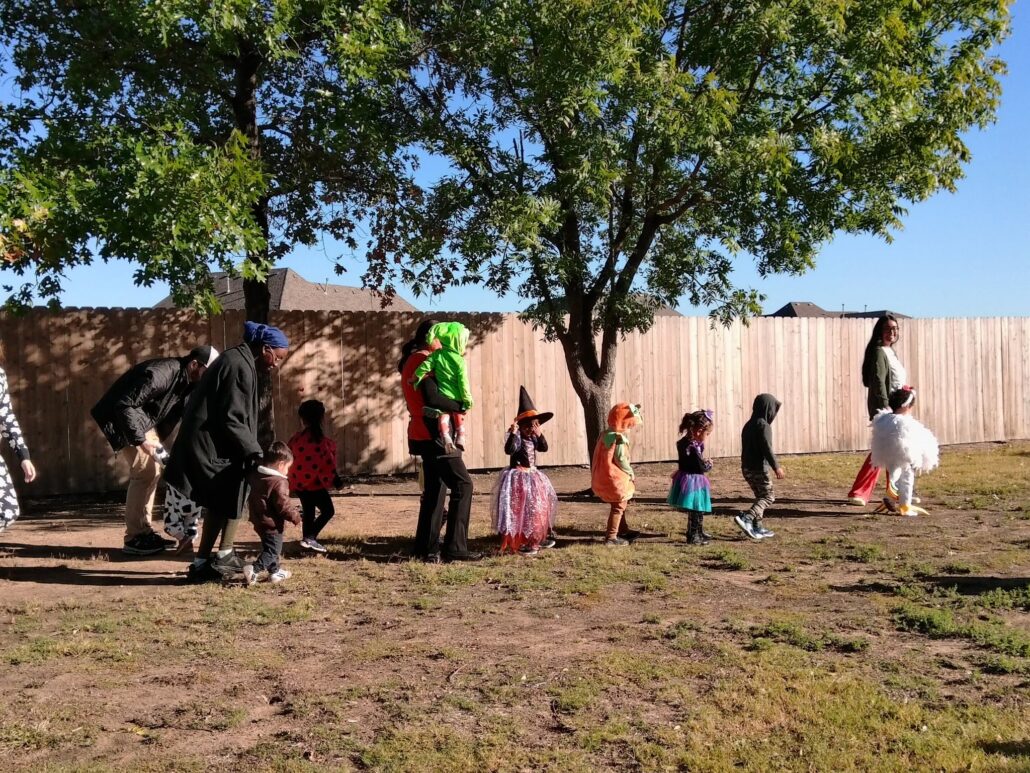 A photo of children walking on grass in halloween costumes outside of preschool and daycare Hebron 336