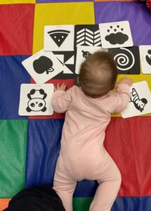 infant playing on ground inside with pictures at cadence academy preschool west o 510