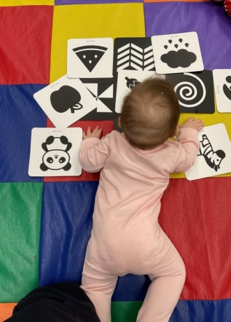 infant playing on ground inside with pictures at cadence academy preschool west o 510