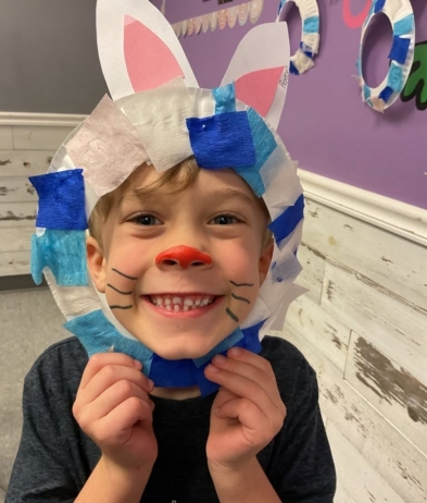 child posing as easter bunny with handmade decorations at cadence academy preschool and daycare west o 510