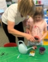 child with mother planting seeds in a cup at cadence academy preschool and daycare west o 510
