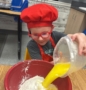 child learning how to cook at kids cafe after school program at cadence academy preschool and daycare west o 510