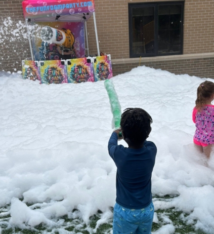 Child playing in foam party outside at cadence academy preschool west o 510