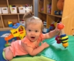 Child playing with toy on ground during tummy time at the professors learning center daycare and preschool elkhorn NE 509
