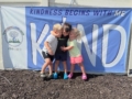 children smiling and hugging in front of kind child sign at the professors learning center daycare and preschool elkhorn NE 509