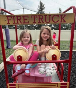 Children posing on playground smiling in firetruck play structure at the professors learning center daycare and preschool elkhorn NE 509