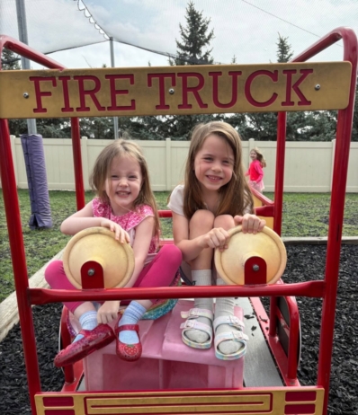Children posing on playground smiling in firetruck play structure at the professors learning center daycare and preschool elkhorn NE 509