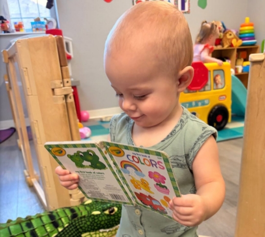Infant holding book and learning to read at the professors learning center daycare and preschool elkhorn NE 509