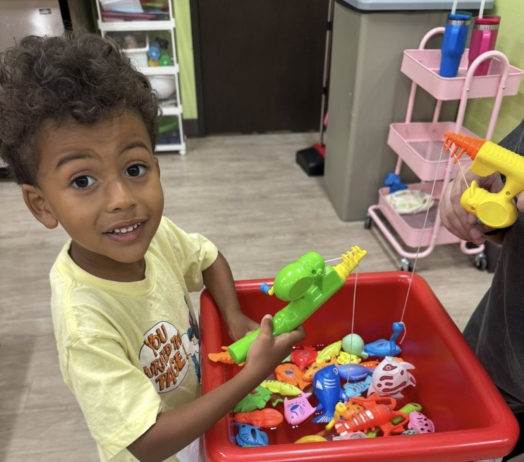 male child playing inside with toys learning at watch me grow riggs