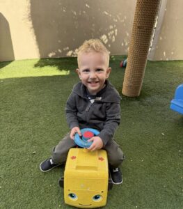 male child playing smiling on playground at watch me grow germann