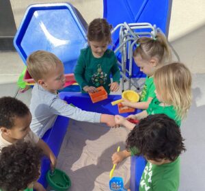 multiple children around sandbox at watch me grow riggs