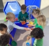 multiple children around sandbox at watch me grow riggs