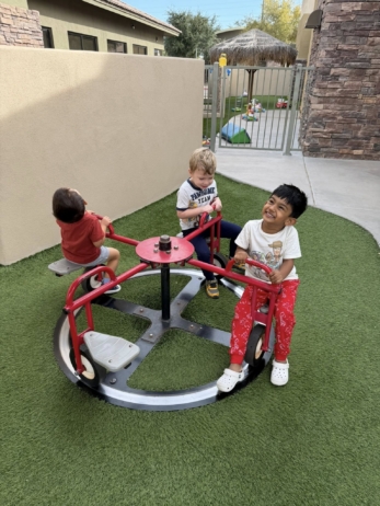 three male children playing outside on playground at watch me grow germann