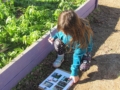 child documenting observations during an outdoor learning activity at natural choice academy