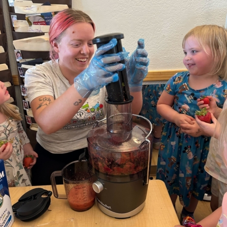 teacher guiding young children through a science activity at natural choice academy