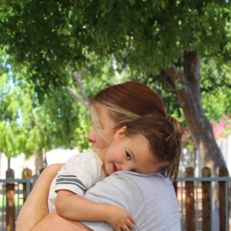 preschool children sharing a comforting hug with teacher during the school day at natural choice academy