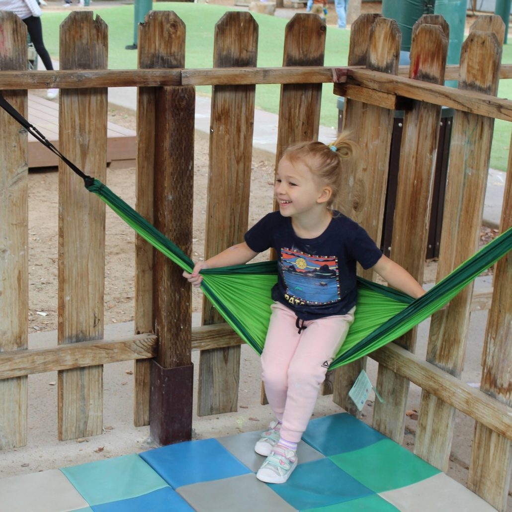 young child enjoying a hammock in the outdoor classroom at natural choice academy