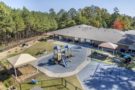 Aerial View Cadence Acaemy Preschool Brier Creek Playground 2 Slides Jungle Gym and Other Activities Safely Enclosed In Back of Facility