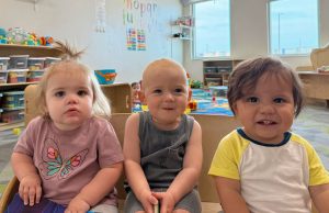 Toddlers smiling at camera in toddler care classroom Generation Next Bondurant