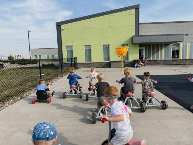 Children playing outside with school in background Generation Next Bondurant