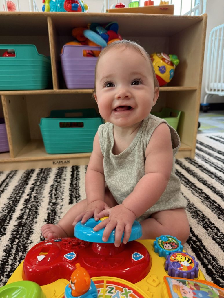 Baby smiling at camera in infant care classroom Generation Next Bondurant