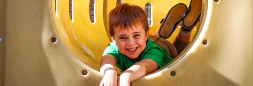 kindergarten child in slide on daycare playground