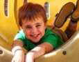 kindergarten child in slide on daycare playground
