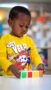toddler boy standing and playing with blocks on a table looking very focused