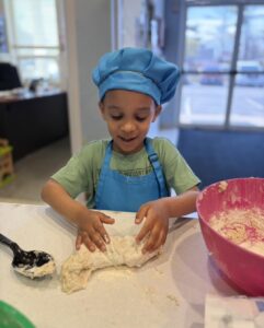 child cooking during kids cafe after school program at 463 precious