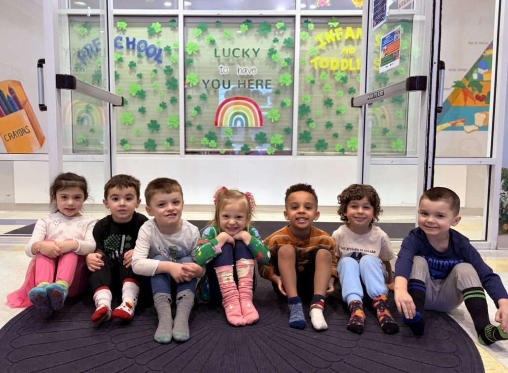 Children sitting in a line smiling at preschool and daycare 463 precious