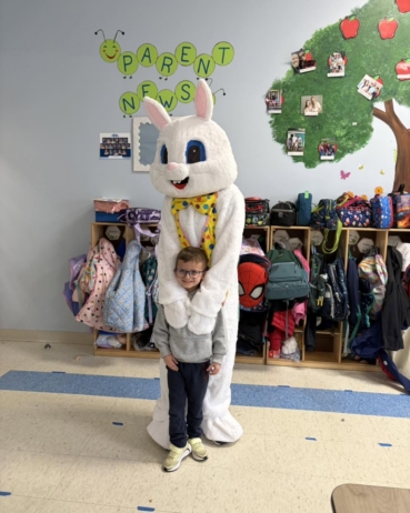 child posing with easter bunny in classroom at 463 precious