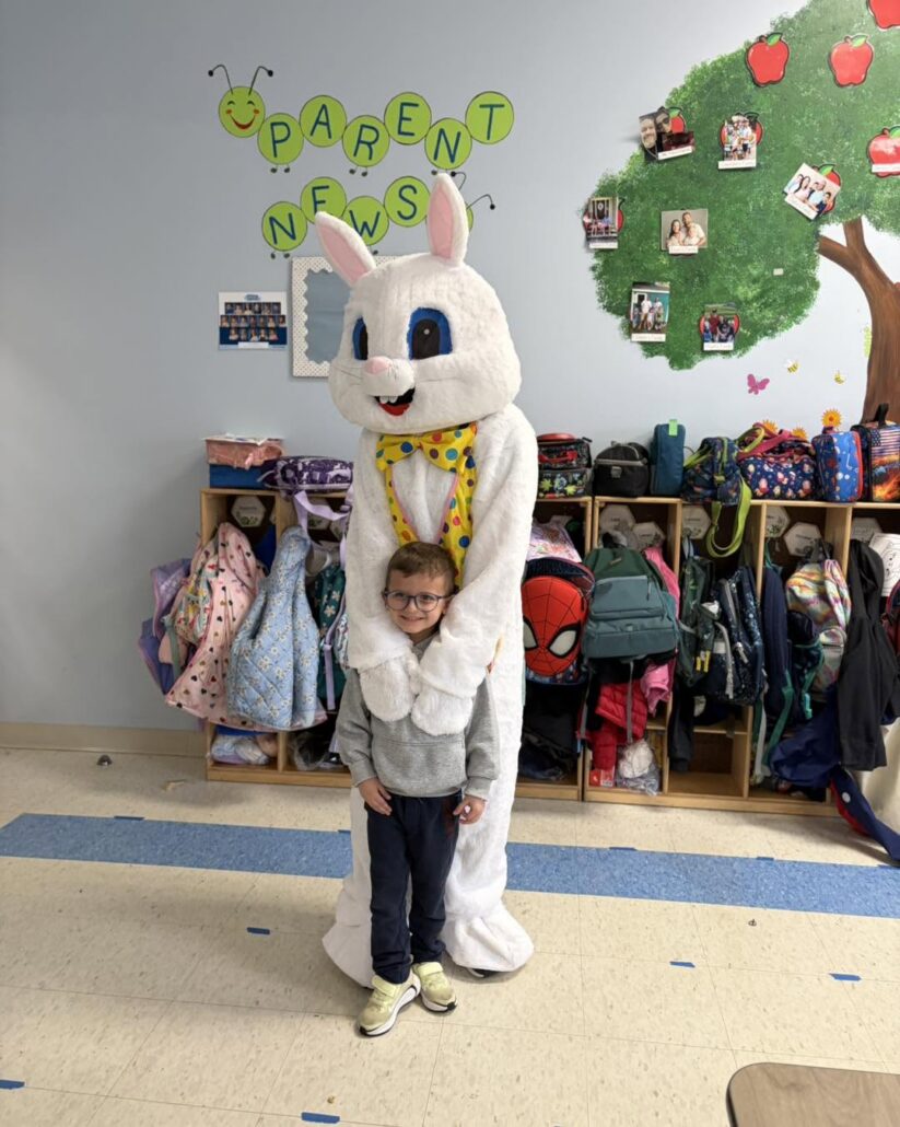 child posing with easter bunny in classroom at 463 precious